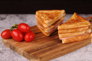 Delicious Ham and Cheese Sandwich with Cherry Tomatoes on a Gray Surface
