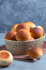 Freshly baked buns in a ceramic bowl.