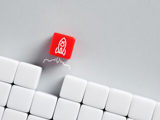 Red dice with rocket breaking through white wall of cubes