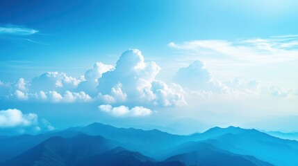 Obraz premium Serene Landscape with Blue Sky and Fluffy White Clouds Over Mountains