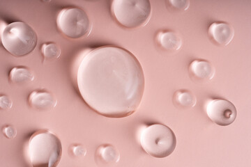 Captivating Macro Shot of Natural Skin Care Gel Drops Set Against a Soft Pink Background
