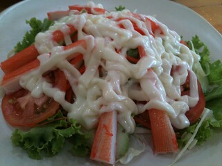 Crab stick and Cucumber slice salad topped with Lettuce tomato, Salad Dressing, Mayonnaise