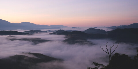 Landscape view of the sea of fog flowing on hills at dawn