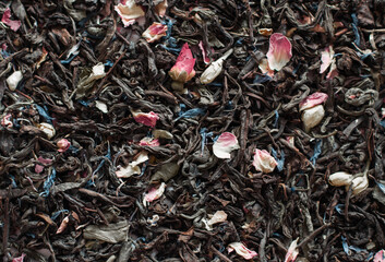 Tea background. Black tea with pink and blue petals. Health. Close-up.