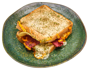 Isolated sandwich featuring melted cheese, layers of deli meat, and green herbs, served on a rustic green plate. Mouthwatering details of this savory meal, perfect for sandwich inspirations.