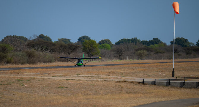 Ultralight aircraft or Microlight aircraft taking off on the runway in Hoedspruit South Africa