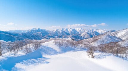Fototapeta premium A stunning snowy landscape with majestic mountains under a clear blue sky, showcasing winter's beauty and serenity.