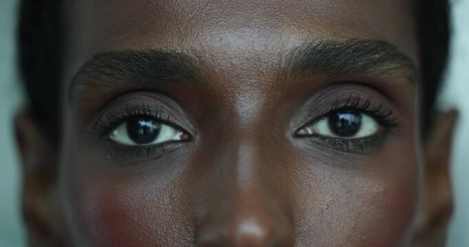 Extreme close up view expressive eyes of beautiful African woman opens eyes and looks at camera having well-defined eyelashes and brows. Natural beauty, confidence, individuality. Eyes window of soul