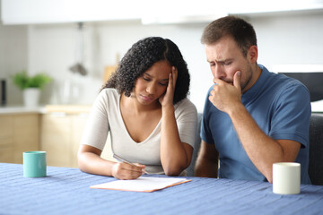Worried interracial couple or roommates checking contract