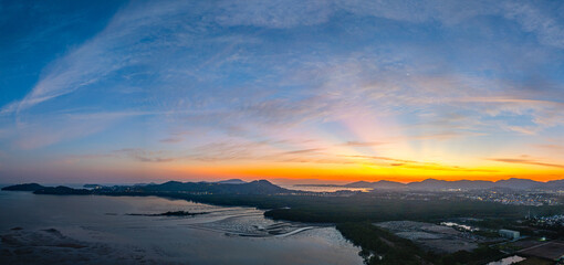 A stunning panoramic view of a coastal city at sunset at Phuket city, showcasing vibrant hues of...