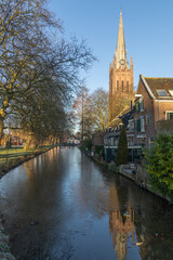Sint Nicolaasbasiliek church IJsselstein surrounded by local houses and canal. IJsselstein, the Netherlands. 11 January 2025. 