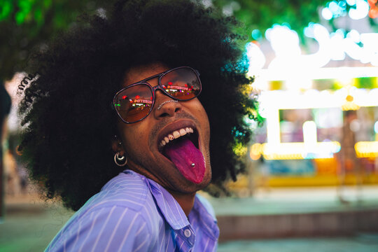 Carefree Afro man wearing sunglasses sticking out tongue