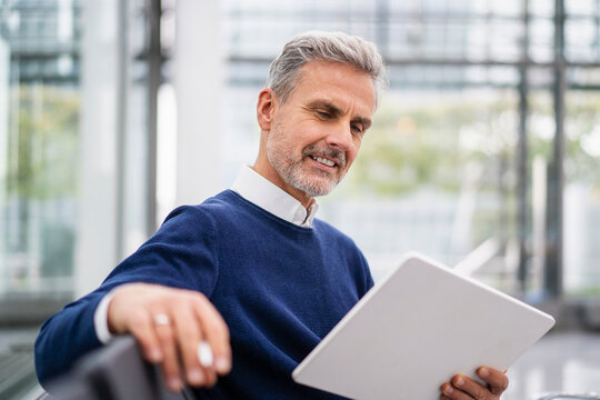 Mature businessman using tablet PC at airport