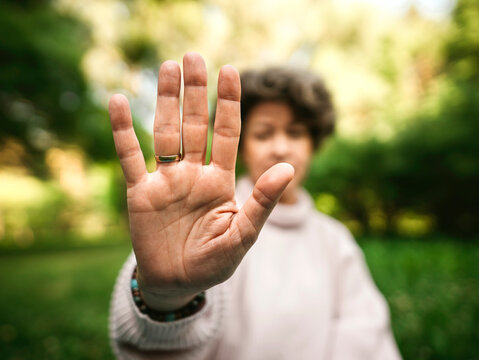 Mature woman gesturing stop sign in public park