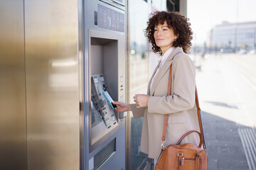 Woman buying train ticket through smart phone in city