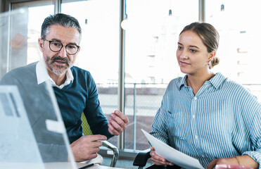 Mature businessman discussing with coworker at office