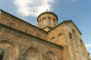 Fototapeta premium A large building with a dome on top and a cross on top of it. The building is brown and has a lot of windows