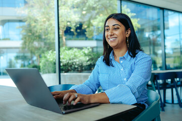 Indian businesswoman working on laptop in modern office