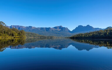 Serene Mountain Lake Reflection in Tasmania's Wilderness Under Clear Blue Sky.