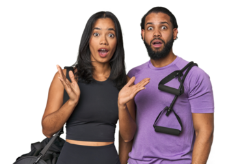Young Latino couple ready for gym training surprised and shocked.
