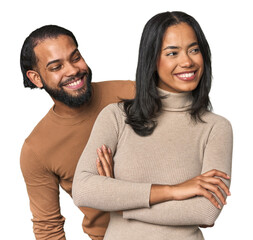 Obraz premium Young Latino couple in studio smiling confident with crossed arms.