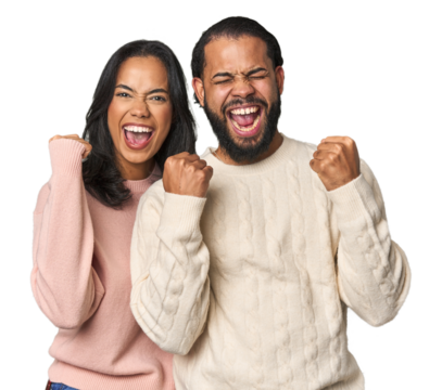 Young Latino couple in studio cheering carefree and excited. Victory concept.