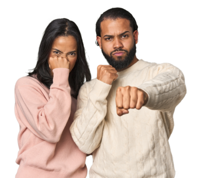 Young Latino couple in studio throwing a punch, anger, fighting due to an argument, boxing.