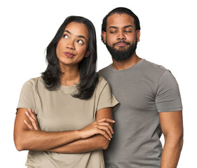 Young Latino couple in studio dreaming of achieving goals and purposes