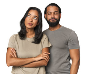 Young Latino couple in studio dreaming of achieving goals and purposes