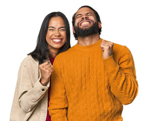 Young Latino couple in studio celebrating a victory, passion and enthusiasm, happy expression.