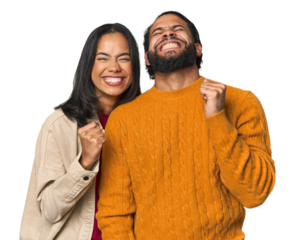 Young Latino couple in studio celebrating a victory, passion and enthusiasm, happy expression.