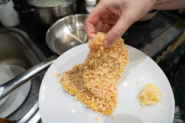 Crumbling meat in breadcrumbs, cooking fillet pieces, turkey breast, homemade schnitzel