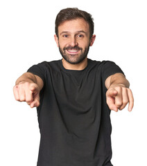 Fototapeta premium Studio portrait of young Hispanic male cheerful smiles pointing to front.