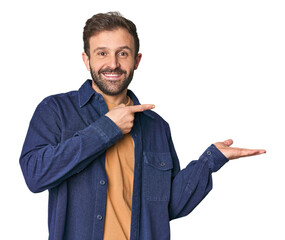 Studio portrait of young Hispanic male excited holding a copy space on palm.