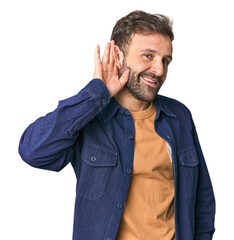 Studio portrait of young Hispanic male trying to listening a gossip.