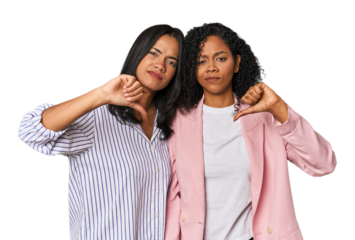 Young Latin businesswomen in studio showing thumb down, disappointment concept.