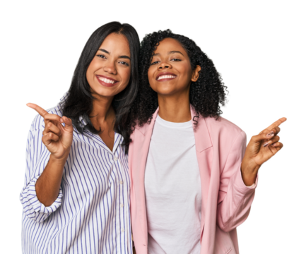 Young Latin businesswomen in studio pointing to different copy spaces, choosing one of them, showing with finger.