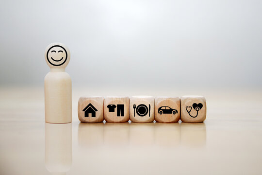 wooden cube with icons of food, Clothing, housing, medical bag, four basic human needs concepts. The Four Basic Material Needs of the Human Being.