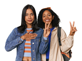 Latin friends ready for vacation taking an oath, putting hand on chest.