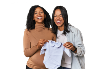 Two Latin women, one pregnant, with baby's bodysuit in studio