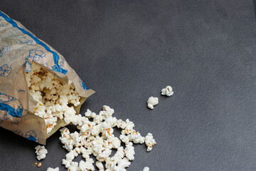 Fresh popcorn in bag made in a microwave on grey kitchen table