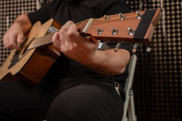 Hand Playing Acoustic Guitar Close-Up, musician practicing chords on instrument, indoor music...