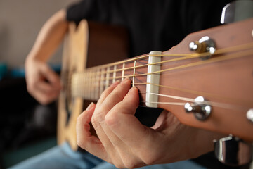 Hand Playing Acoustic Guitar Close-Up, musician sitting indoor, leisure strumming, practice of...