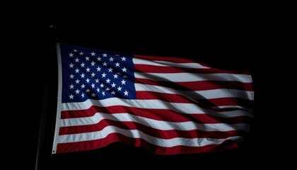 Obraz premium An American flag waving in the wind on a dark black background