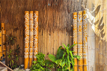 Bamboo fence with decorative art elements, outdoor decor. Natural textures, tropical plants with...