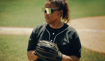 Confident baseball player wearing stylish sunglasses, holding a glove on a sunny day