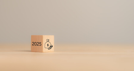 2025 financial, budget planning and management concept. Wooden blocks displaying the year 2025 and a money bag icon, symbolizing financial, budget planning, saving money, investment, economic growth..
