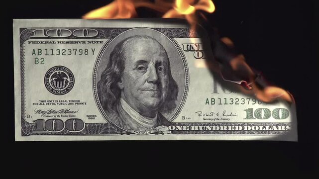Burns Money. A $100 bill slowly burns against a black background, symbolizing a deep economic crisis and financial losses