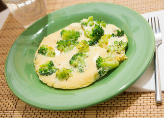 Wholesome breakfast. omelet with broccoli on green plate