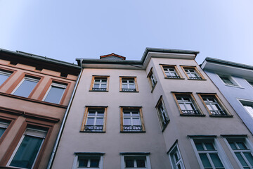 Houses with intricate window designs and charming architecture under a bright sky in a European city